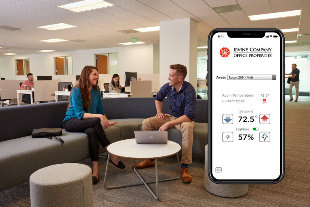 Two people talking in an office with the Comfort Control app managing lighting and temperature in side the building